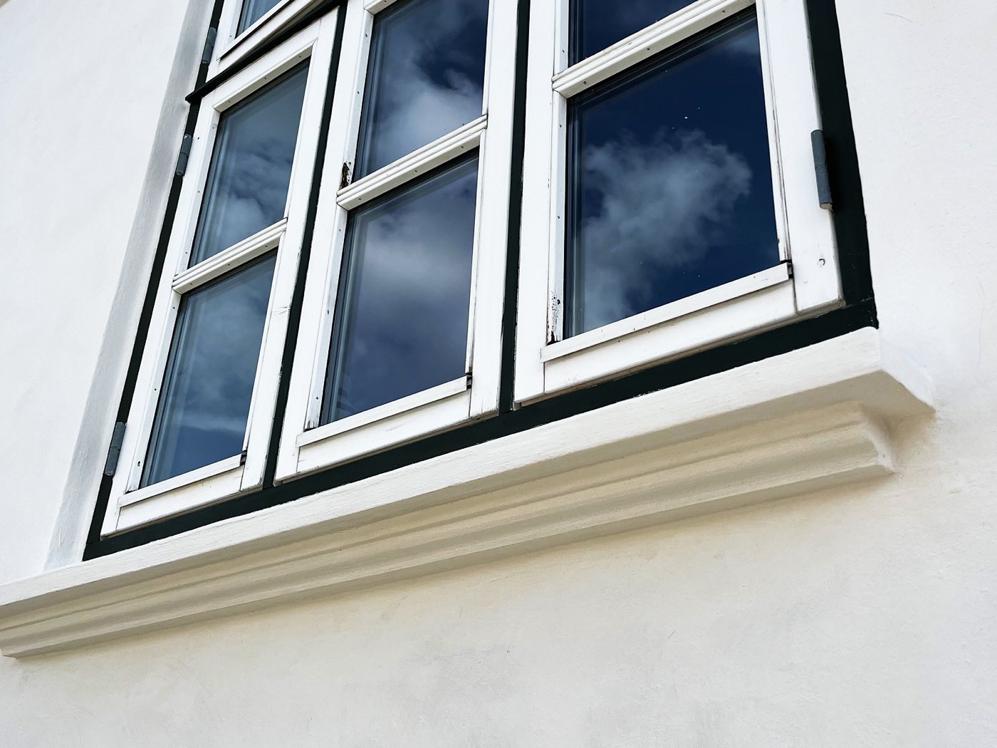 Nystøbt sålbænk under et vindue på en facade fra Promurer
