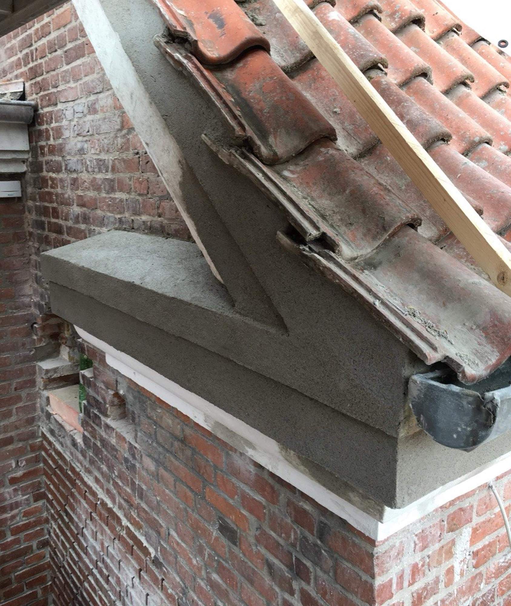 Murer fra Promurer arbejder på en trukket gesims på en ældre teglstensfacade